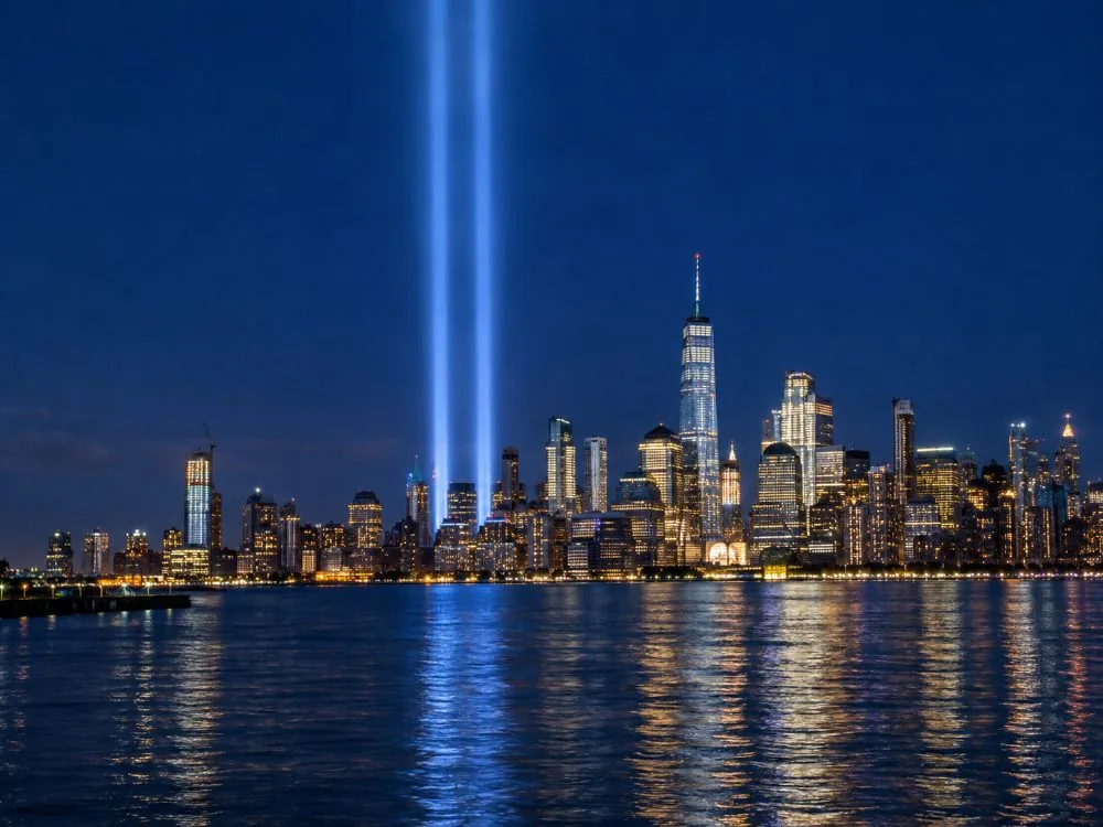 Deux faisceaux lumineux s'élevant au-dessus de Lower Manhattan la nuit